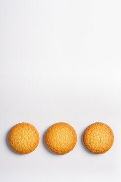 Three golden oat cookies in a row isolated on white background vertical