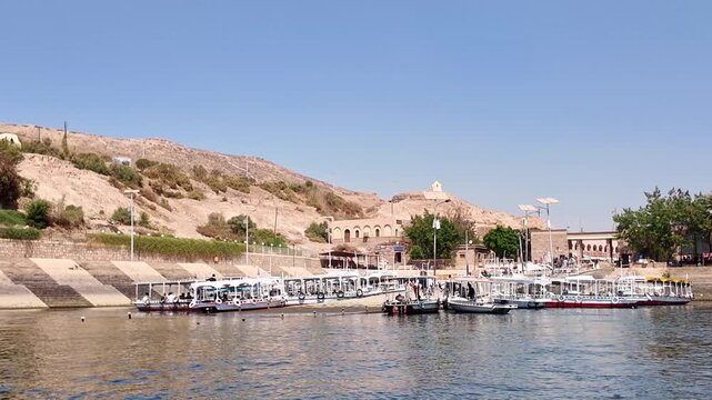 Motorboats carrying tourists arriving at the dock of the ancient philae temple on agilkia island. Famous historical landmark on the nile river