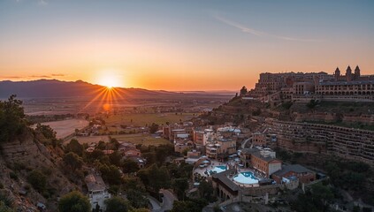 Obraz premium Sunset Over a Scenic Hillside Resort with Pool and Mountains in Background