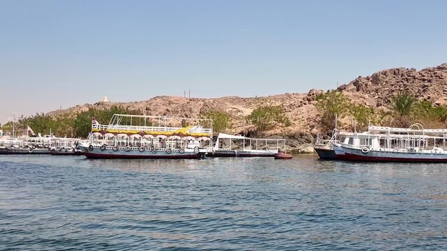 Traditional egyptian tourist boats docking at the agilkia island pier. A historical landmark on the nile river, the philae temple complex in aswan