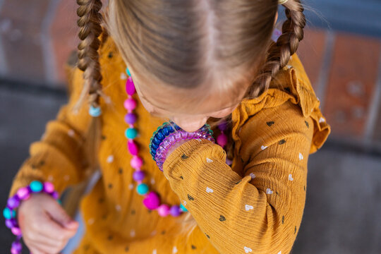 Little girl biting colourful chewelry bracelets for sensory stim