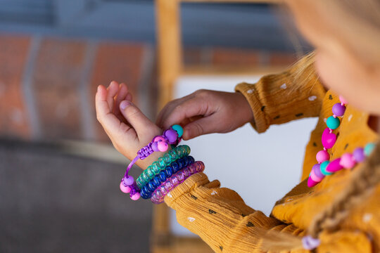 Little girl wearing colourful chewelry bracelets for sensory stim