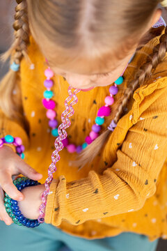 Little girl biting colourful chewelry bracelets for sensory stim