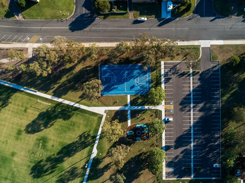overhead aerial view of recreation area with park court and sports field by carpark