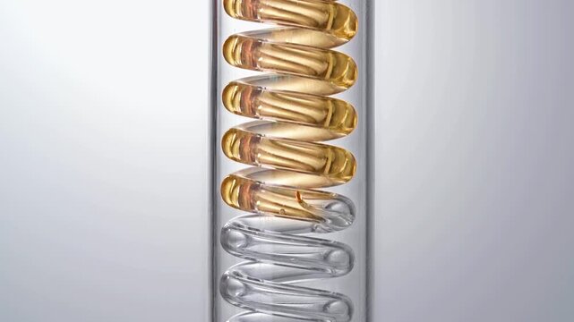 Macro video of pure golden liquid flowing in glass spiral condenser tube, medical science chemistry lab cosmetic skincare essential oil distillation