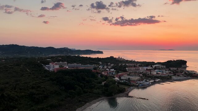 Aerial drone view of a luxury sea resort hotel in Roda North Corfu Greece during vibrant colorful orange sunset amber sky twilight
