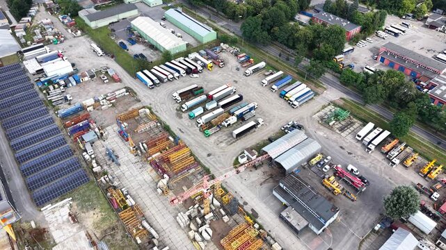 Aerial view of an industrial zone showcasing transport enterprises and factories, highlighting the layout of buildings, vehicles, and equipment in a bustling commercial area