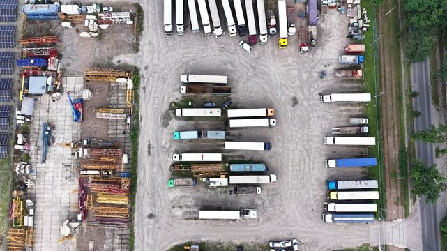 Aerial view of an industrial zone showcasing transport enterprises and factories, highlighting the layout of buildings, vehicles, and equipment in a bustling commercial area