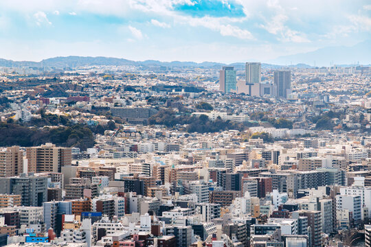 密集する都市のビル群と遠くに広がる丘陵地帯の風景