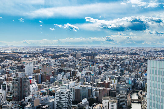 近代的なガラスビルと川沿いに広がる都市のパノラマ風景