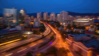 Obraz premium Blurred Cityscape with Busy Roads and Illuminated Skyscrapers at Dusk