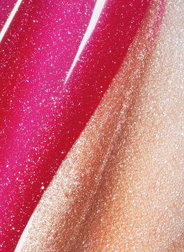 Pink and gold shimmering lip gloss texture background. Smudged cosmetic product smear. Makup swatch product sample