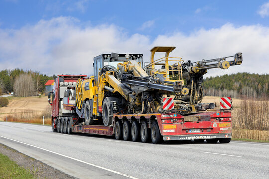 Volvo FH16 truck transports Atlas Copco Boomer open pit mining drilling rig on Faymonville trailer along highway. 