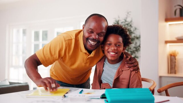 Education, father and son with hug in home for child development, homework help or learning. Smile, study and support with African family embracing at counter for assistance or school assignment