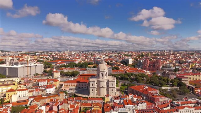 A drone pulls back from a domed landmark expanding into a wide view of red rooftops and dramatic clouds