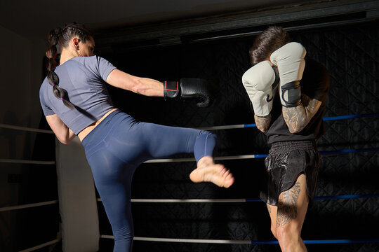 Female fighter performing kickboxing during mma sparring