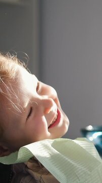Little girl smiling patiently in dentist's chair