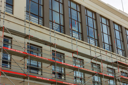Metal scaffolding stands against a multi‑story building in Wellington, New Zealand