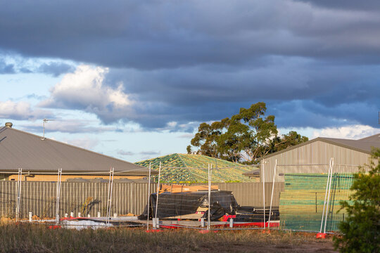 new house builds under construction and materials stockpile for worksite