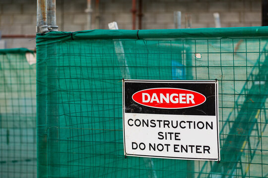 green worksite fence with danger construction site do not enter sign