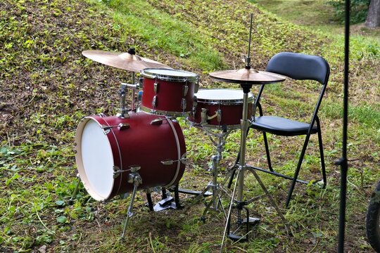 Jazzette type drum kit with bass drum, tom and bass tom, and two cymbals. Outdoor drumset placed on grass.