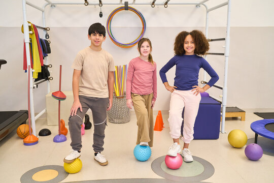 Children in pediatric physiotherapy session, balance training with rehabilitation exercises, therapist with children in pediatric rehab center, physical therapy session