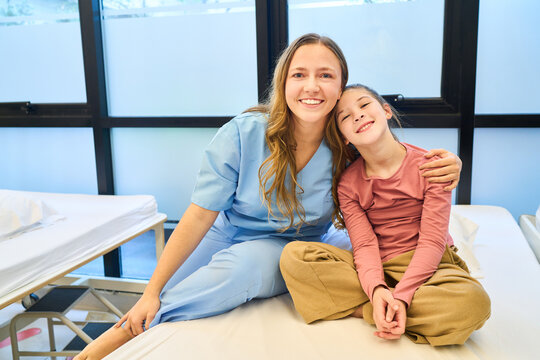Pediatric Physiotherapist with Child Patient in Rehab Center, Smiling Therapist with Young Girl Doing Rehabilitation Exercises, Child Physiotherapy Session