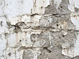 Fototapeta premium Closeup of old weathered white paint peeling off concrete wall surface