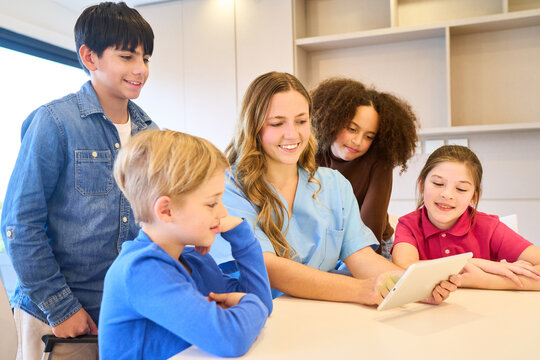 Pediatric Physiotherapist with Children Using Tablet, Rehabilitation Exercises, Motor Skills Training, Pediatric Rehab Center, Physical Therapy Session, Smiling