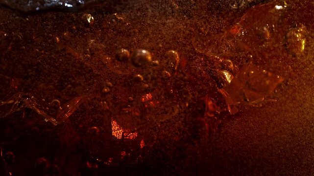 Super Slow Motion Shot of Ice Falling into Fresh Cola Lemonade at 1000fps.