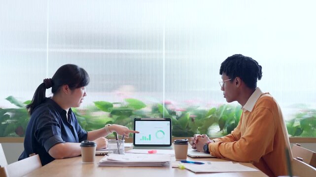 Diverse young colleagues working together on laptop computer in modern office, business collaboration concept