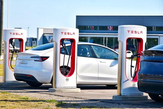 July 10, 2026, Helsingborg, Sweden. An electric car charges at a modern charging station. Tesla charging stations in a parking lot.