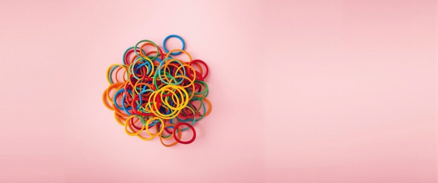 Colorful Rubber Bands Piled on a Pink Background