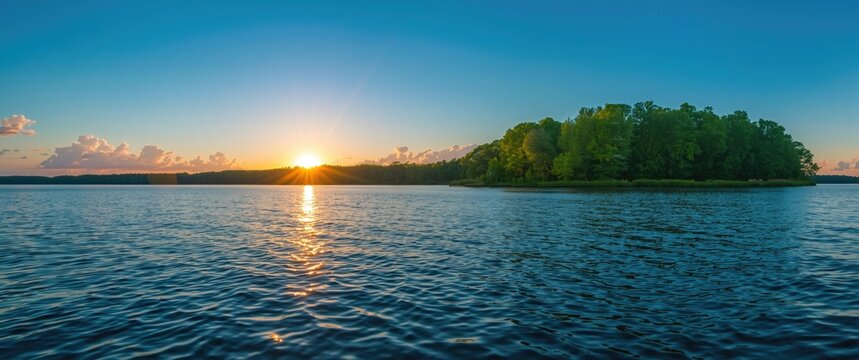 Sunrise Over Tranquil Lake with Lush Island and Clear Blue Sky