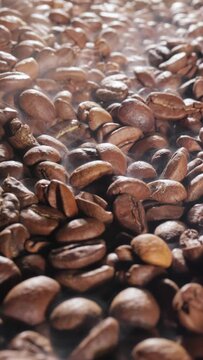 Steaming roasted coffee beans background with selective focus.