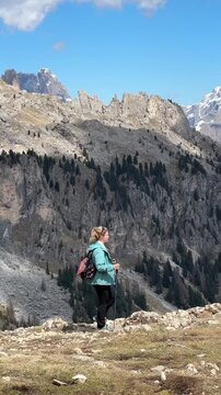 Woman hiking near Rifugio Roda di Vael in the Dolomites, Italy. Scenic trekking trail through the Rosengarten (Catinaccio) massif near San Giovanni di Fassa. Outdoor adventure