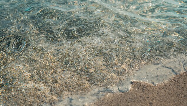 Clear Ocean Waves Gently Lapping on Sandy Shore in Soft Light