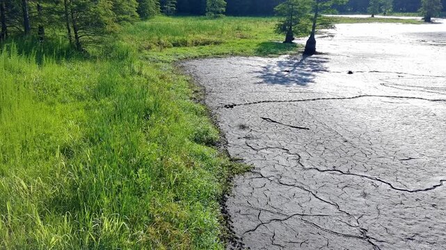 Aerial footage from a drone of the drying mud bottom of a drought stricken pond. 
