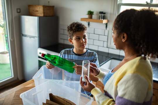 Parent and child sorting recycling in home kitchen