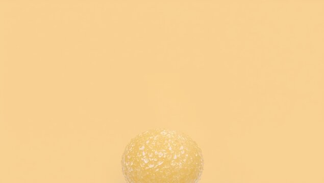 Textured Yellow Sphere Isolated on Soft Orange Background