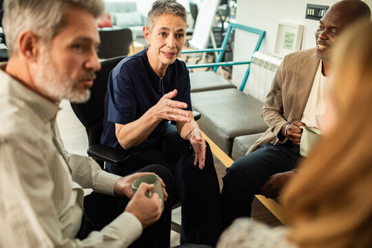 Diverse adults discussing ideas in office lounge