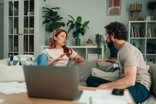 Couple having serious discussion about financial planning and household budget at home living room