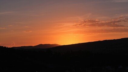 Fototapeta premium Sunset Over Hills with Colorful Sky and Silhouetted Landscape