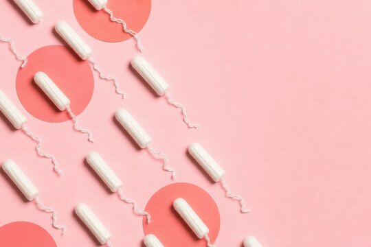 White tampons with strings arranged on pink background, menstrual hygiene concept