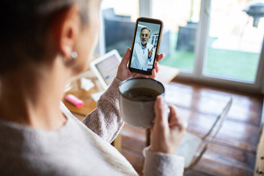 Woman on smartphone telehealth video call at home