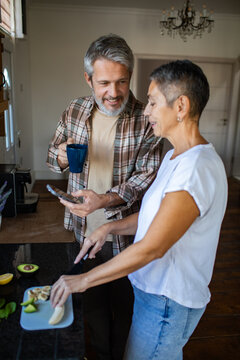 Mature couple preparing healthy breakfast together in home kitchen