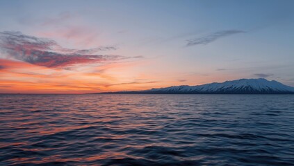Fototapeta premium Mountain Reflection on a Calm Ocean During Sunset Sky with Colorful Clouds