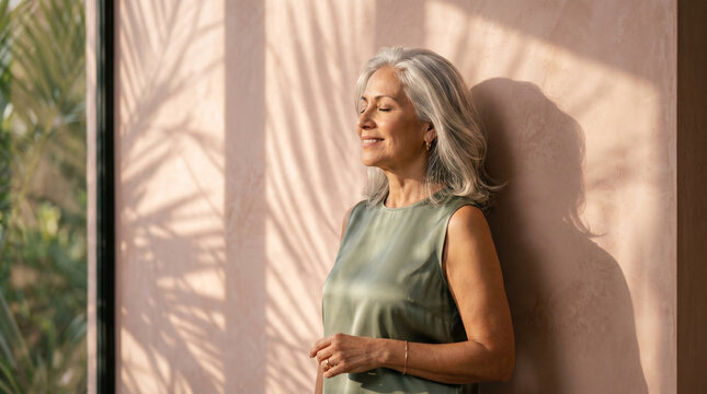 Mature Woman Enjoying Sunlight by Window at Home