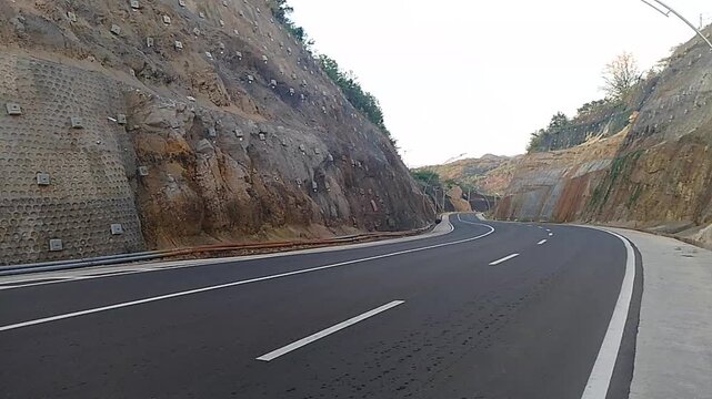 Scenic Curved Road Carved Through Rocky Hills in Labuan Bajo, Indonesia