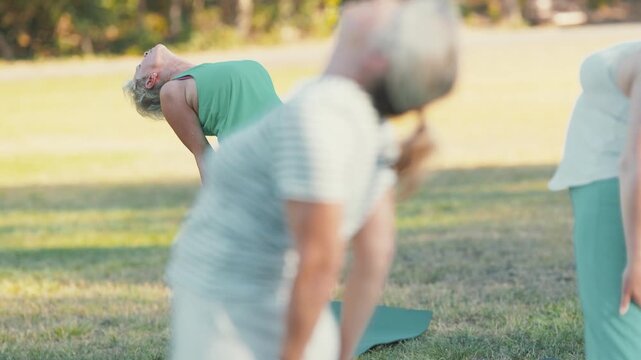 Senior woman stretching back during outdoor yoga class